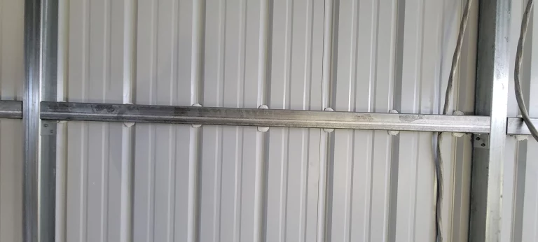 Corrugated metal wall interior with metal framing and sealant