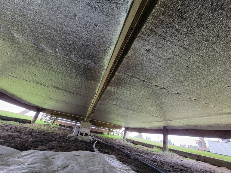 Agricultural building crawl space with reflective underfloor insulation.