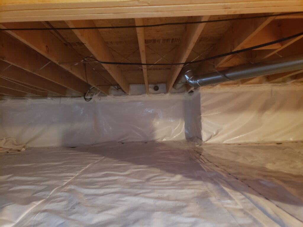 Finished crawl space encapsulation with sealed vapor barrier and insulated foundation walls to improve energy efficiency and moisture control