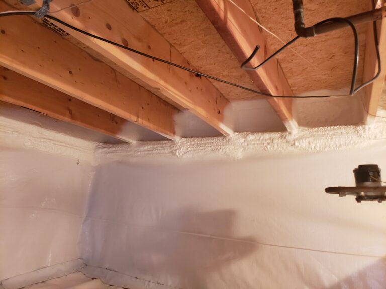 Spray foam insulation applied to crawl space rim joists to reduce air leakage and improve energy efficiency