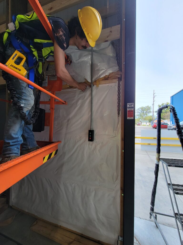 Colony Insulation technician installing insulation and air sealing materials in a commercial building to improve energy efficiency and thermal performance