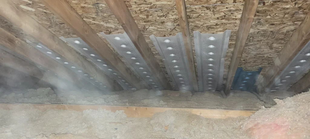 Attic ventilation baffles installed above loose-fill cellulose insulation to maintain proper airflow and improve energy efficiency