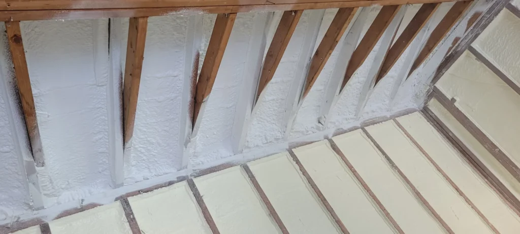 Closed-cell spray foam insulation installed along attic roof framing and knee wall areas to improve energy efficiency and air sealing